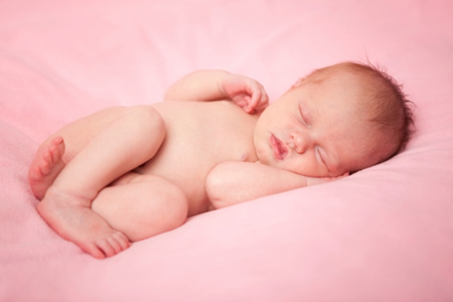 Newborn Baby Girl Sleeping Peacefully on Pink Blanket
